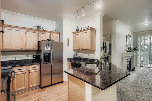 a kitchen with granite countertop a sink stove and refrigerator