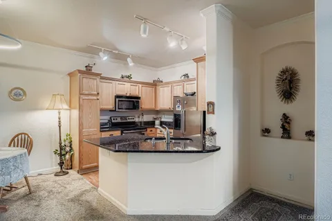 a kitchen with stainless steel appliances granite countertop a sink and a refrigerator