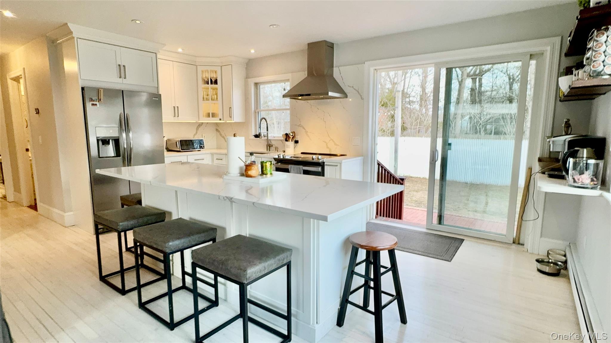 4 North Westbury Road Hampton Bays, NY 11946 - Photo 4 of 20 a kitchen with stainless steel appliances a dining table chairs and chandelier