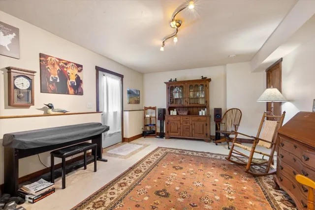 a living room with furniture a dining table and paintings on the wall