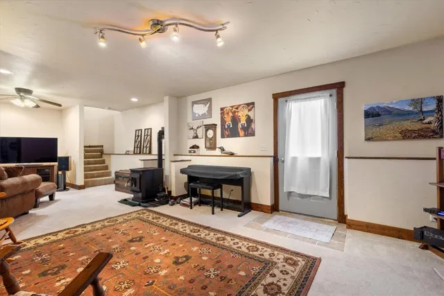 a living room with furniture a rug and kitchen view