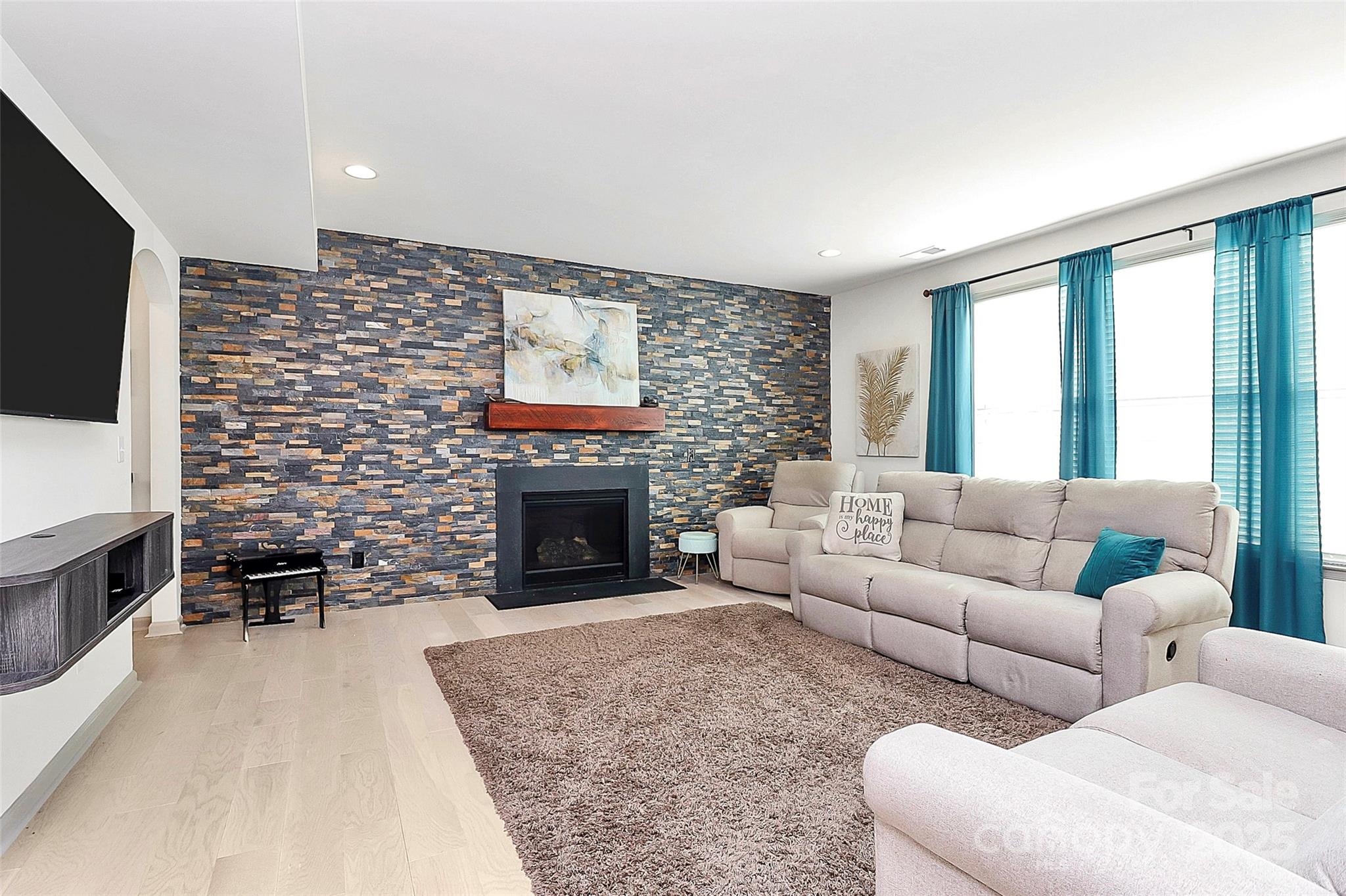 7362 Millstone Circle Southwest Concord, NC 28025 - Photo 4 of 45 a living room with furniture a flat screen tv and a fireplace