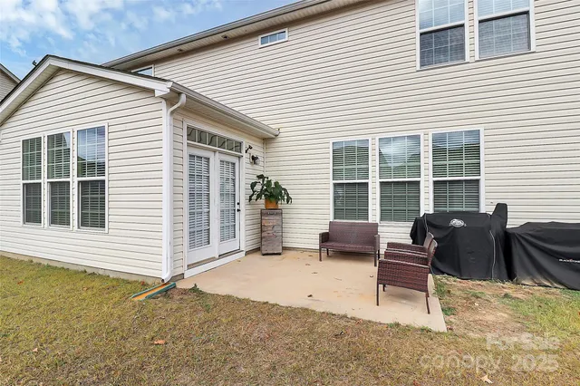 a view of a house with a patio and a yard