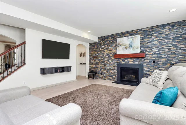 a living room with furniture a flat screen tv and a fireplace