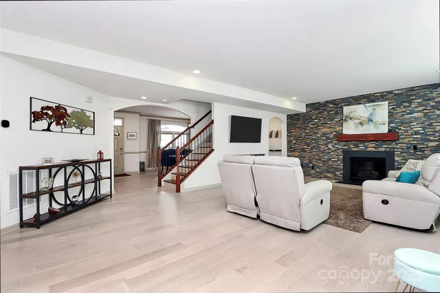 a living room with furniture a fireplace and a flat screen tv