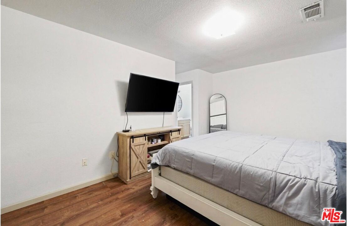 5612 McKee Road Bakersfield, CA 93313 - Photo 15 of 22 a bedroom with a bed and a flat screen tv