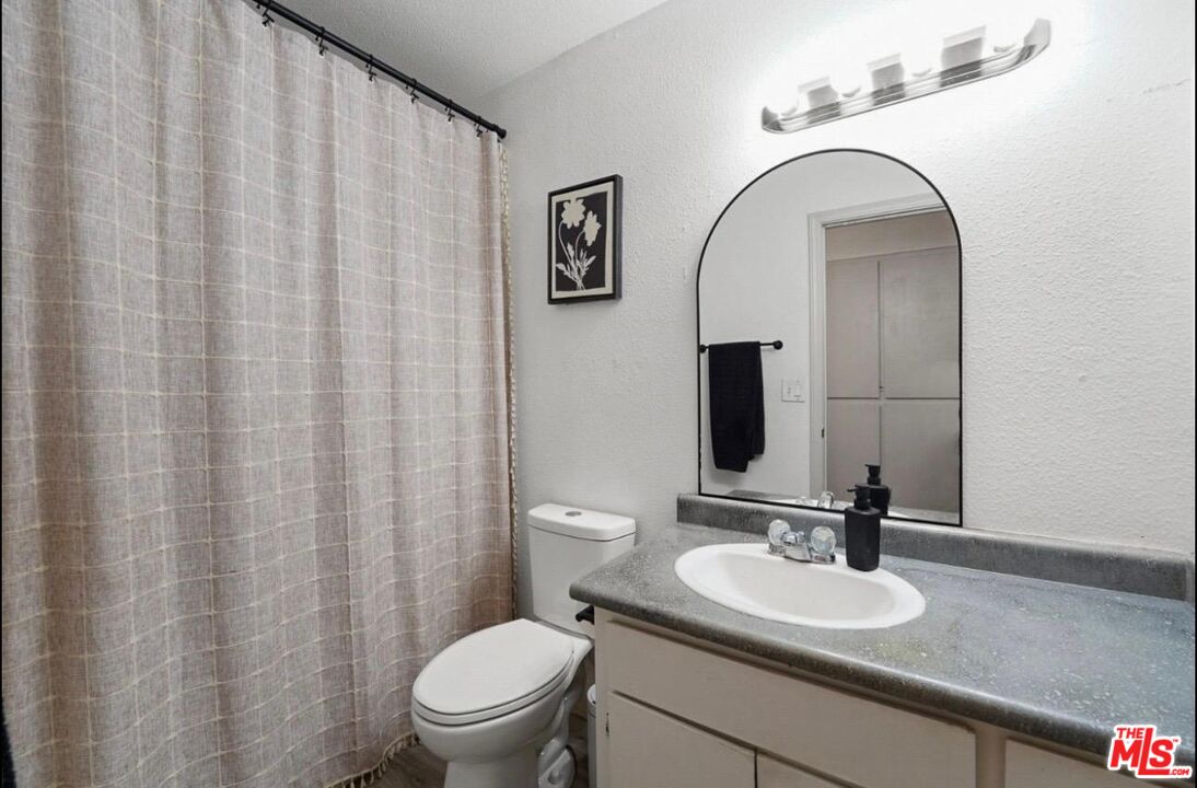 5612 McKee Road Bakersfield, CA 93313 - Photo 17 of 22 a bathroom with a granite countertop sink and a mirror with toilet