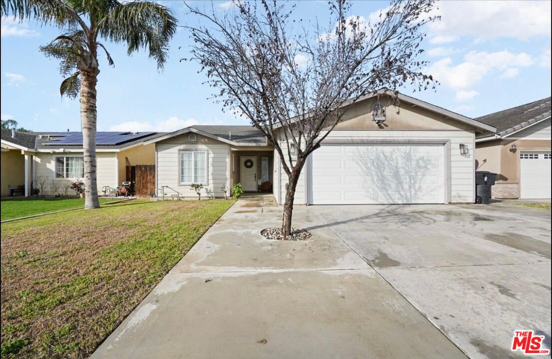 5612 McKee Road Bakersfield, CA 93313 - Photo 3 of 22 a front view of a house with a yard and garage
