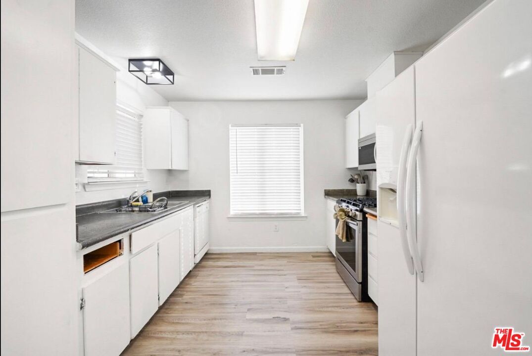 5612 McKee Road Bakersfield, CA 93313 - Photo 10 of 22 a kitchen with a refrigerator a sink and a stove
