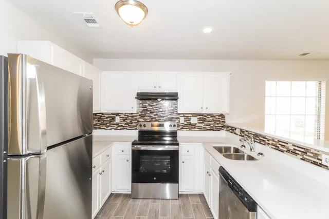 a view of a room with a large window and chandelier