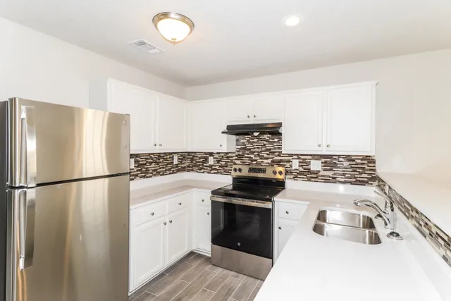 a kitchen with a stove a sink and a refrigerator
