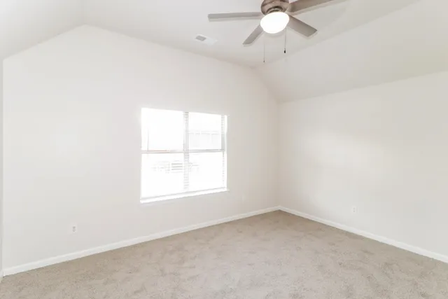 an empty room with a window and a fan