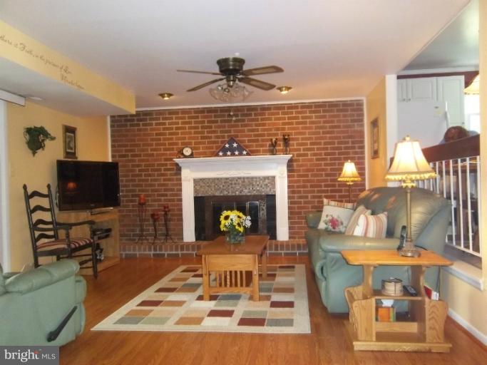 4825 Vicky Road Nottingham, MD 21236 - Photo 7 of 24 a living room with furniture a flat screen tv and a fireplace