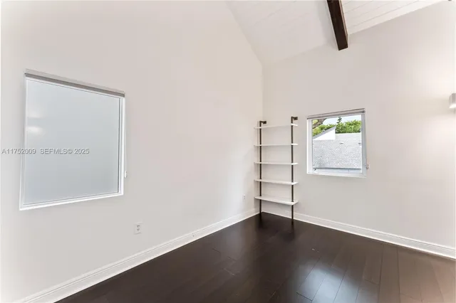 a view of a hallway with wooden floor and a chandelier