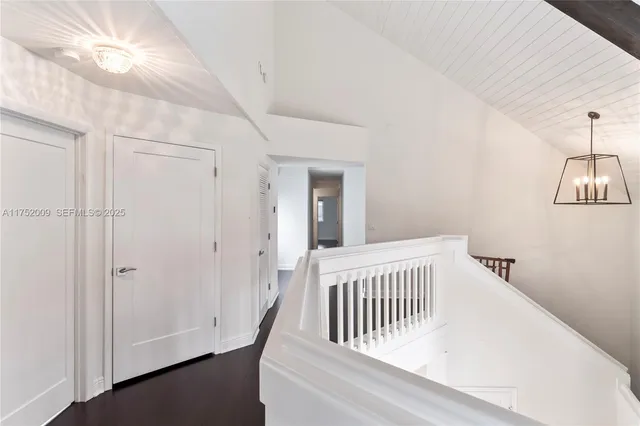 a large kitchen with kitchen island a large window a refrigerator a sink and cabinets