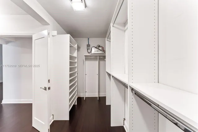 a view of a room that has a bed and wooden floor