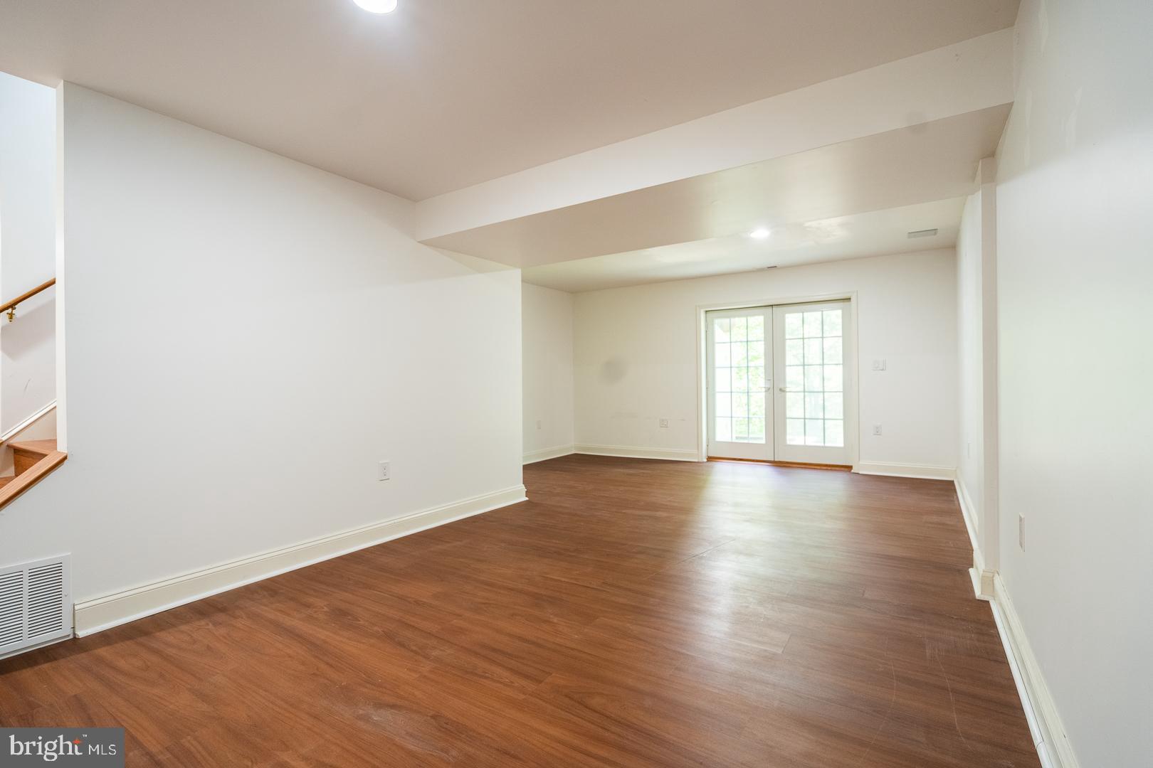 5705 Solomons Island Road St. Leonard, MD 20685 - Photo 38 of 46 an empty room with wooden floor and windows