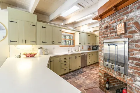 a large kitchen with stainless steel appliances granite countertop a sink refrigerator and cabinets