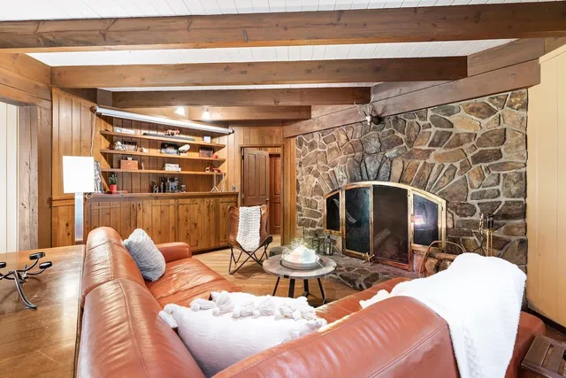 a living room with furniture a flat screen tv and a fireplace