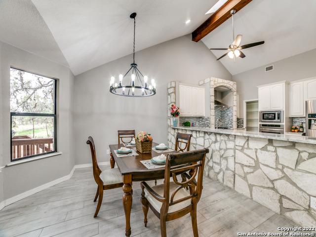2580 Goat Hill Road Lakehills, TX 78063 - Photo 15 of 34 a view of a dining room with furniture a chandelier and wooden floor