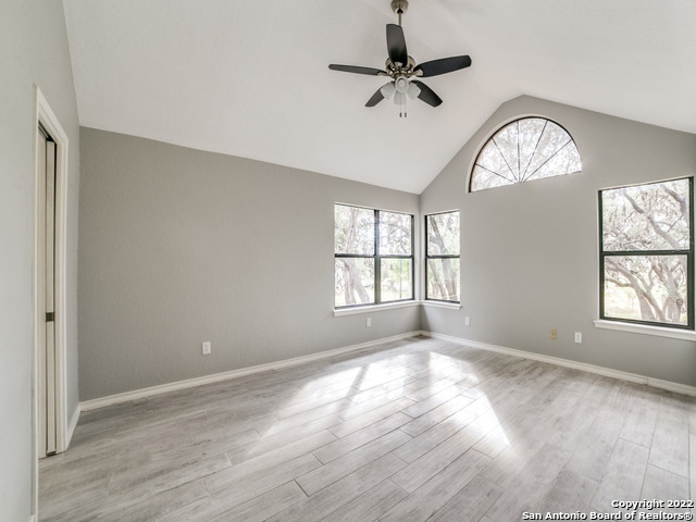 2580 Goat Hill Road Lakehills, TX 78063 - Photo 17 of 34 an empty room with wooden floor chandelier fan and windows