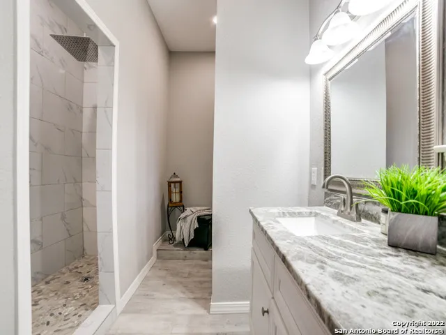 a bathroom with a granite countertop sink a toilet and shower