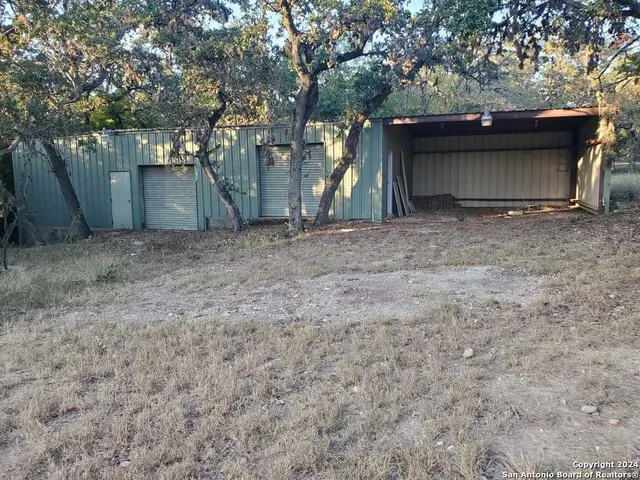 a view of a tiny house with a large tree
