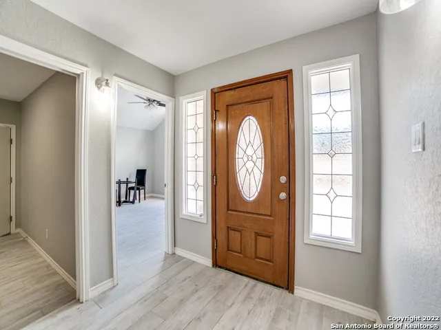 a view of a hallway with wooden floor windows and a bathroom