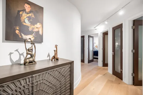 a spacious bedroom with a bed and dresser with mirror