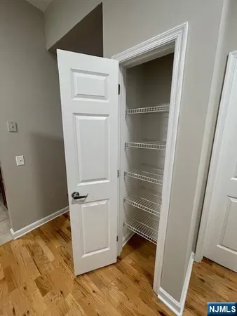 a view of walk in closet with wooden floor