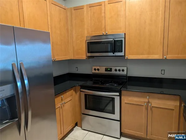 a kitchen with stainless steel appliances granite countertop a stove a microwave and a sink