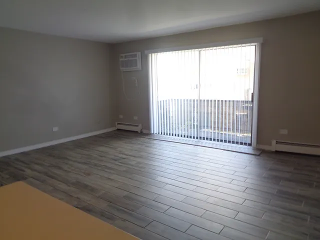a view of a room with wooden floor and a window