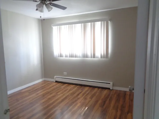 an empty room with a window and wooden floor