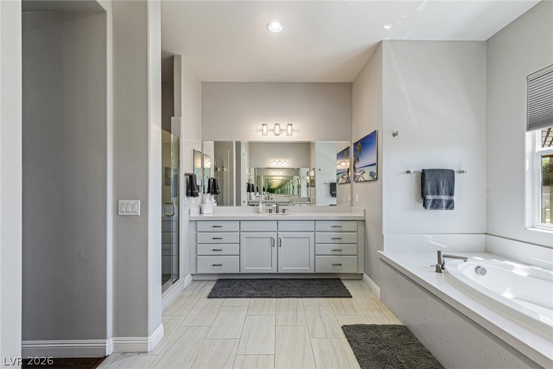 7036 Arabian Ridge Street Las Vegas, NV 89131 - Photo 30 of 64 Spa-inspired ensuite featuring a separate soaking tub, walk-in shower, and dual sinks and vanities.