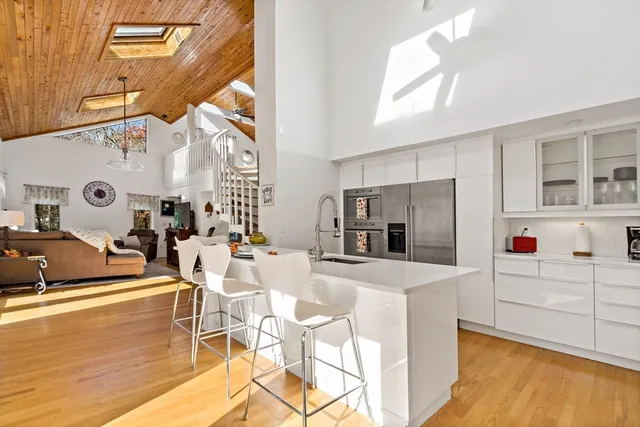 a large kitchen with stainless steel appliances kitchen island granite countertop a refrigerator and a stove