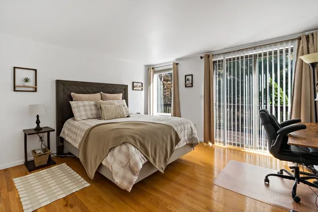 a bedroom with a bed wooden floor and a couch
