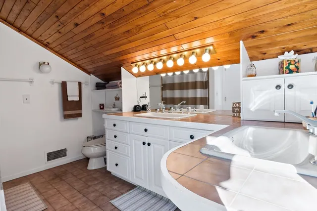 a spacious bathroom with a large tub and sink