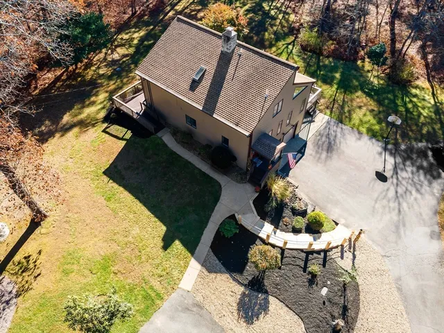 a backyard of a house with table and chairs and wooden fence