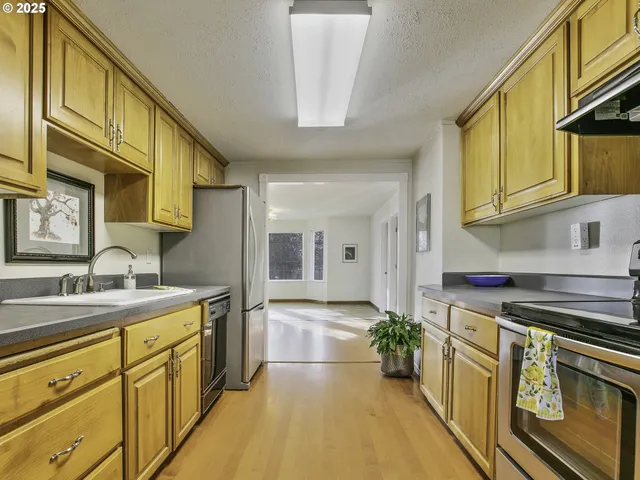 a kitchen with stainless steel appliances granite countertop a sink a stove and cabinets