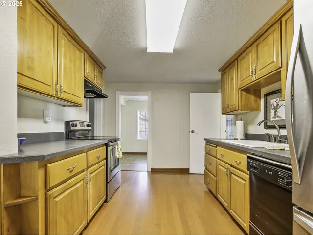 a kitchen with stainless steel appliances granite countertop a sink a stove and cabinets