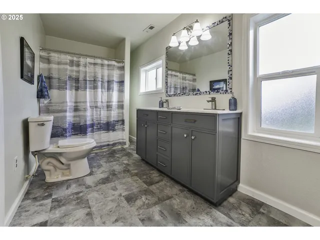 a bathroom with a sink toilet mirror and shower