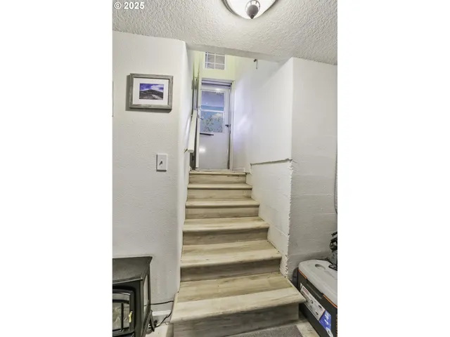 a view of a hallway with stairs and a white walls