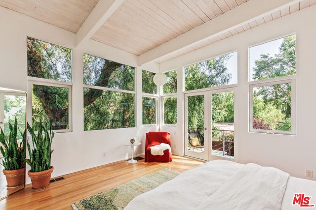 a bed sitting in a bedroom next to a window