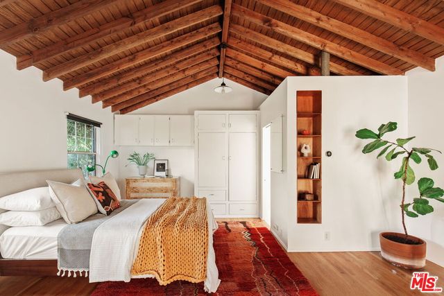 a bedroom with a bed and a potted plant