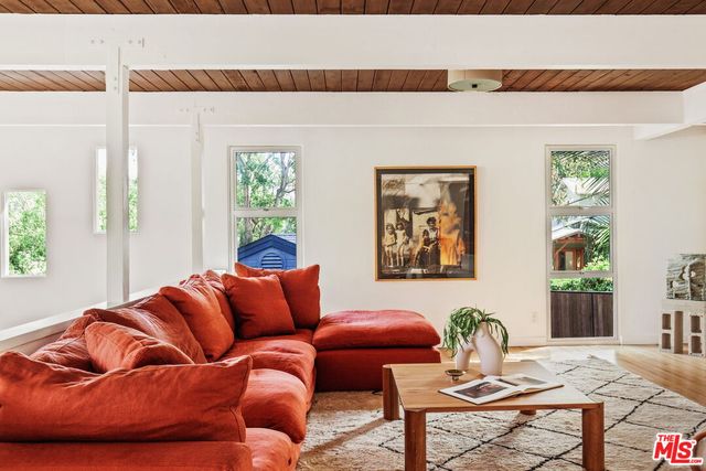 a blue couch sitting in a living room next to a window