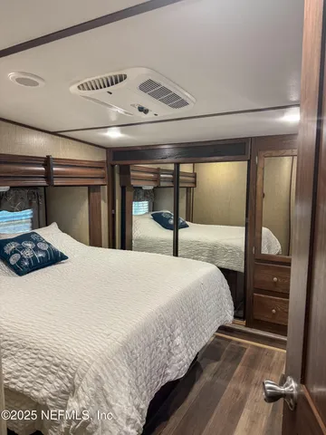 a bedroom with a large bed and a mirror