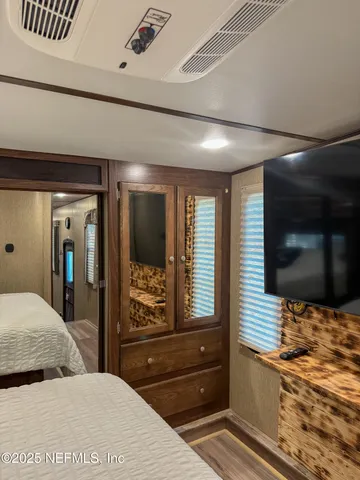 a bedroom with a bed and a flat screen tv