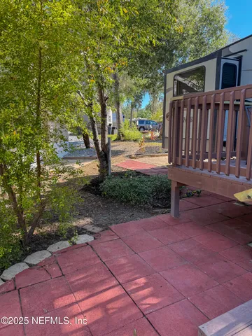 a view of a patio with table and chairs and wooden fence