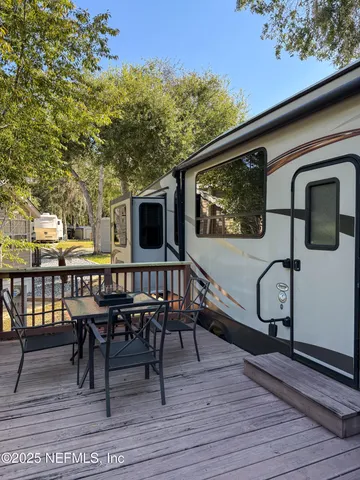 a view of a deck with table and chairs with wooden floor and fence