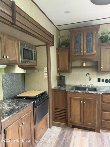 a kitchen with granite countertop a sink and wooden cabinets